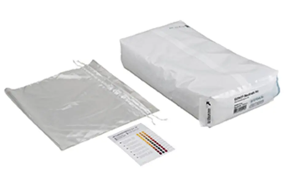 Wartungsset von Grünbeck mit einem weißen, verpackten Element und einem transparenten Beutel, daneben eine farbige Skala zur Analyse oder Messung.